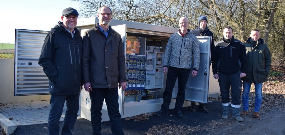 Gruppenfoto vor dem neuen Verteilerkasten mit Vertretern der EAM Netz, der Energie Marburg-Biedenkopf und der Gemeinde Münchhausen