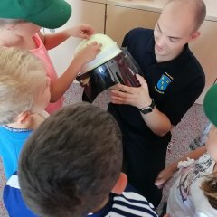 Kinder fassen den Feuerwehrhelm an