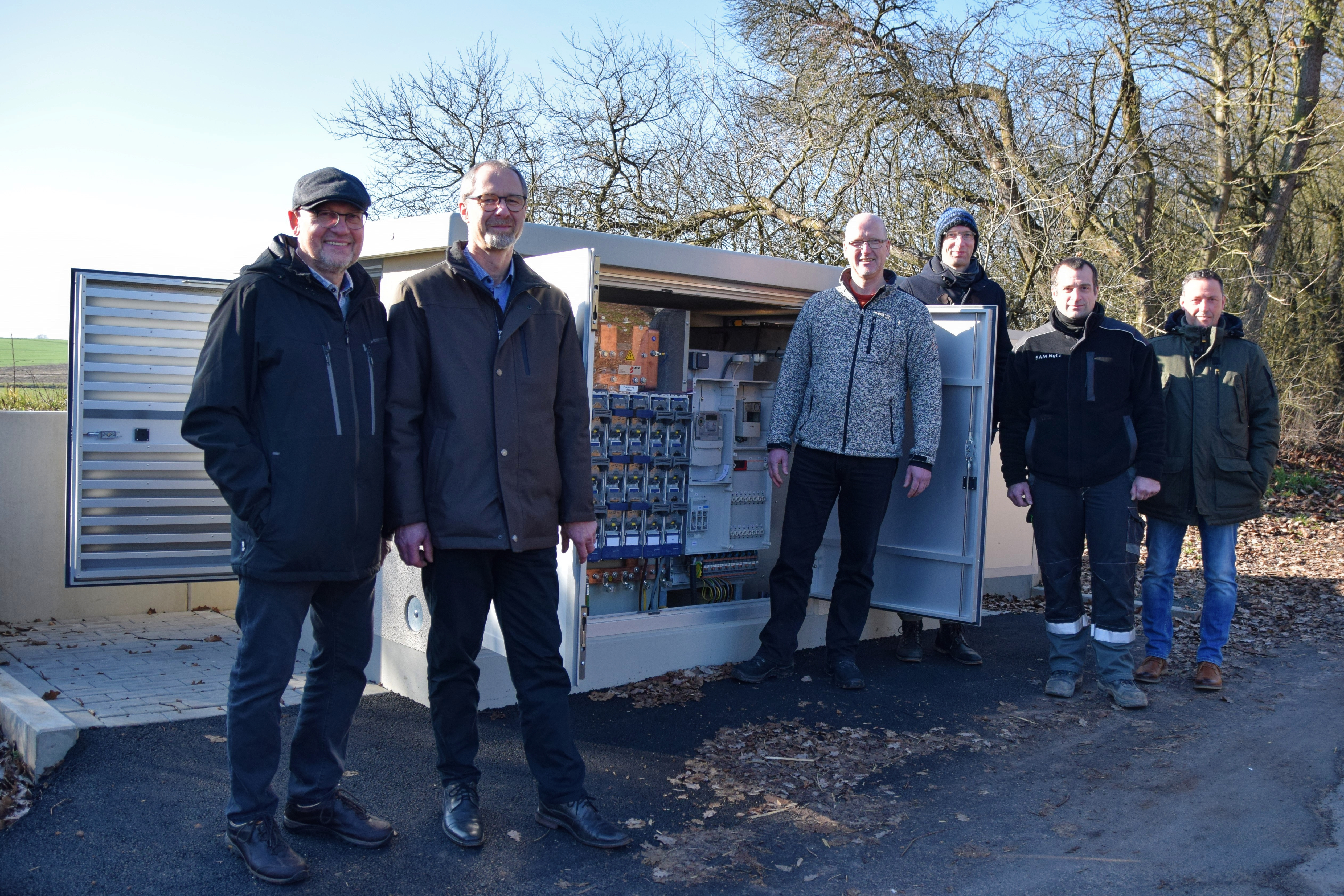 Gruppenfoto vor dem neuen Verteilerkasten mit Vertretern der EAM Netz, der Energie Marburg-Biedenkopf und der Gemeinde Münchhausen
