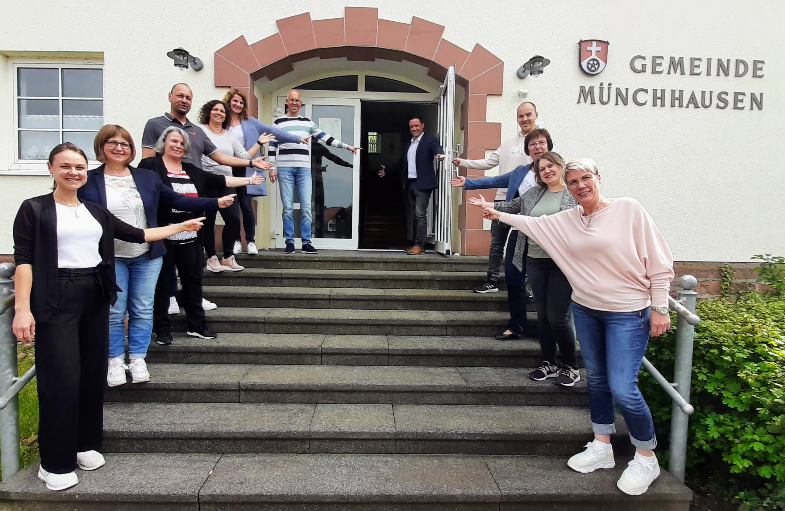 Bild Team Gemeindeverwaltung vor offener Rathaustür