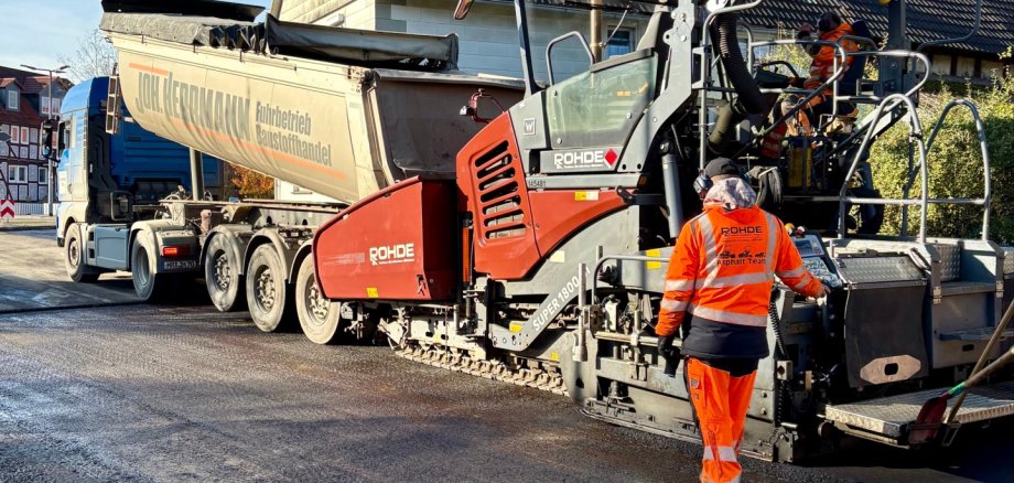 Der Asphalt für die neue Deckschicht wird mit einer Teermaschine aufgetragen